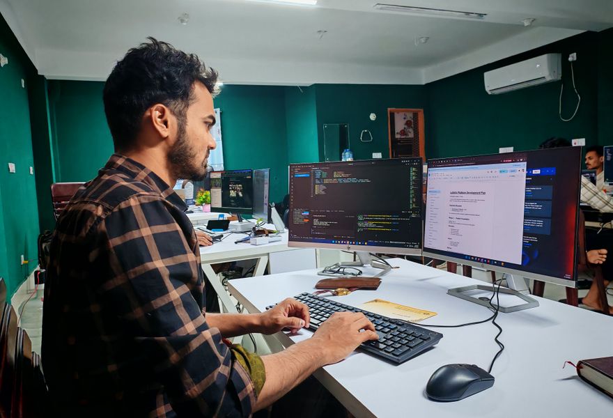 Software developer building an application at a dual-monitor workstation
